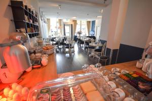 ein Restaurant mit einer Theke, auf der Essen angeboten wird in der Unterkunft Hotel Bridges House - Delft City Centre in Delft