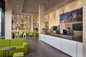 eine Lobby mit einem Wartezimmer mit grünen Stühlen in der Unterkunft Super 8 by Wyndham Mainz Zollhafen in Mainz