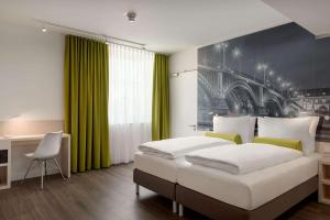 ein Schlafzimmer mit einem großen Bett und einer grünen Wand in der Unterkunft Super 8 by Wyndham Mainz Zollhafen in Mainz