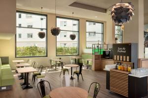 ein Restaurant mit Tischen und Stühlen und Fenstern in der Unterkunft Super 8 by Wyndham Mainz Zollhafen in Mainz