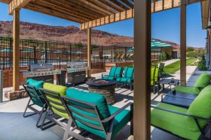 un patio con sedie e un grill con montagne sullo sfondo di Wingate by Wyndham Moab a Moab