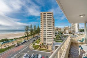 a balcony with a view of a beach and a building at Eden Tower in Gold Coast