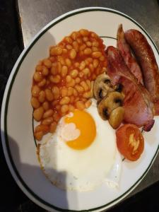 a plate of food with eggs bacon beans and mushrooms at Church Farm Accomodation in Bickenhill