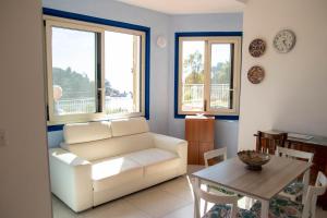 a living room with a white couch and a table at Taormina Isola bella suite in Taormina