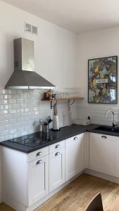 a kitchen with white cabinets and a black counter top at Belle Malouine in Saint Malo