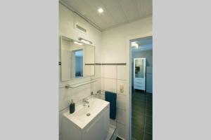 a white bathroom with a sink and a mirror at Exklusives Apartment inklusive Netflix und Parkplatz in Karlsruhe