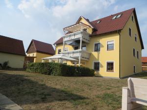 a yellow house with a red roof at Pension-Gästehaus Küblböck in Neualbenreuth +3 photos