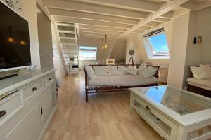 un ampio soggiorno con divano e TV di Appartement Vue Mer - Cabourg - Normandie a Cabourg