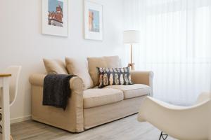 a white living room with a couch and a lamp at Os Fragosinhos in Funchal