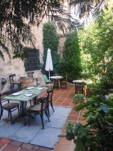 un patio con mesas, sillas y una sombrilla en Posada de Candelario en Candelario