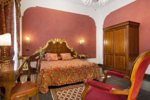 a bedroom with a bed and a dresser and chairs at Residenza d'Epoca San Cassiano in Venice