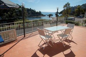 - une table et des chaises sur une terrasse avec vue sur l'océan dans l'établissement Taormina Isola bella suite, à Taormine