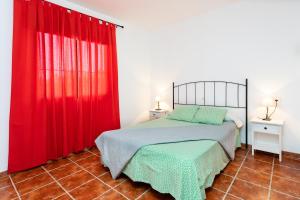 1 dormitorio con cortinas rojas y 1 cama en una habitación en Live Don Jose 204, en Costa del Silencio