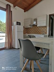cocina con mesa de madera y silla en Casa di Roby 4L en Marrùbiu