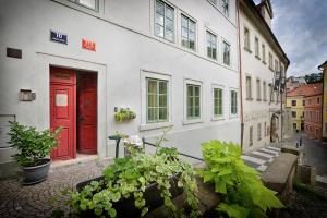 a red door on the side of a white building at Nobles Apartments in Prague