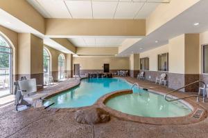 een zwembad in het midden van een hotelkamer met een spa bij Comfort Suites Frisco in Frisco