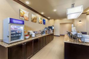 a large kitchen with a counter with a refrigerator at Comfort Suites Frisco in Frisco
