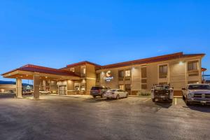 een hotel met auto's geparkeerd op een parkeerplaats bij Comfort Inn at Buffalo Bill Village Resort in Cody