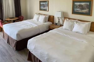 um quarto de hotel com duas camas e uma mesa em Rodeway Inn em Edson