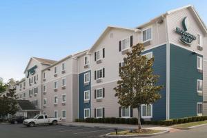a large apartment building with a car parked in a parking lot at WoodSpring Suites Gainesville I-75 in Gainesville