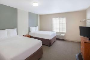 Giường trong phòng chung tại WoodSpring Suites Jacksonville Beach Blvd