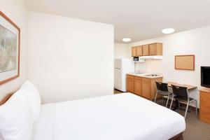 een hotelkamer met een bed en een keuken bij WoodSpring Suites Tyler Rose Garden in Tyler