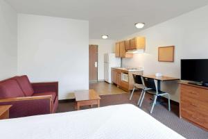 um quarto de hotel com uma cama e uma cozinha em WoodSpring Suites Tyler Rose Garden em Tyler