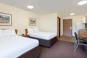 A bed or beds in a room at WoodSpring Suites Tyler Rose Garden