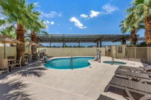 a swimming pool with chairs and palm trees at Comfort Inn & Suites North Tucson Marana in Tucson