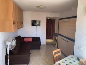 uma sala de estar com um sofá e uma cozinha em LyriosHomes Estudio Arcos Playa Benalmádena em Arroyo de la Miel
