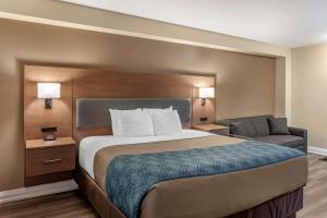 Habitación de hotel con cama y silla en Econo Lodge Inn & Suites Downtown, en Toronto
