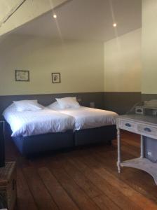 a bedroom with a large bed and a table at Hotel In't Boldershof in Deurle