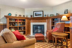 a living room with a couch and a fireplace at Comfort Inn Warrensburg Station in Warrensburg