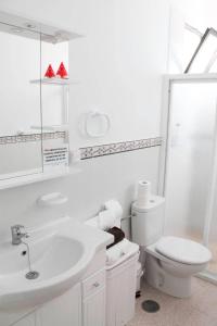 a white bathroom with a toilet and a sink at VV Canteras Oasis "by henrypole home" in Las Palmas de Gran Canaria
