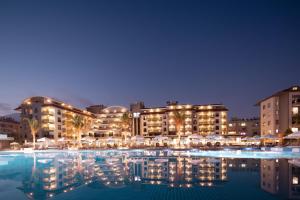 a hotel with a swimming pool at night at Green Garden Resort & Spa Hotel in Alanya