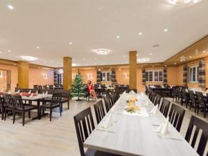 uma sala de jantar com mesas e cadeiras e uma árvore de Natal em Landgasthof Schwarzes Roß em Ansbach