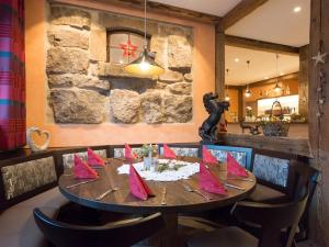 comedor con mesa de madera y servilletas rojas en Landgasthof Schwarzes Roß, en Ansbach