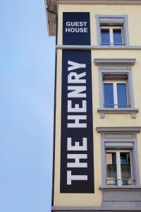 The Henry Self Check-In Guesthouse في زيورخ: علامة على جانب مبنى مع بيت ضيافة