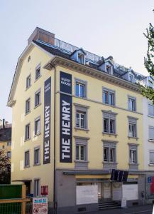 a yellow building with a sign on the side of it at The Henry Self Check-In Guesthouse in Zurich