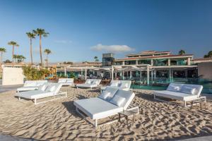 a group of white lounge chairs on the beach at Kumara Serenoa By Lopesan Hotels in Maspalomas