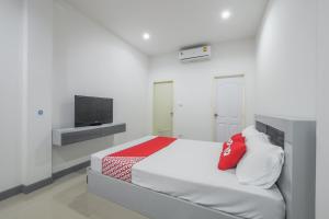 una camera bianca con letto e televisore di OYO 1159 K&k Apartment a Samutprakarn