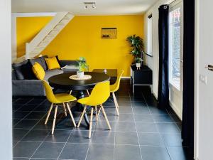 uma sala de jantar com uma mesa e paredes amarelas em 't zeeuwse achteruusje em Sint Annaland