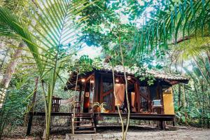 a cabin in the middle of a forest with palm trees at Canto Leela Eco Bungalows in Serra Grande