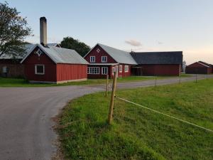 einen Bauernhof mit einer roten Scheune und einer Straße in der Unterkunft Komleryd in Långås