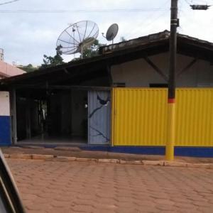 een geel en blauw gebouw met een satelliet bij Pousada Sírius in São Roque de Minas