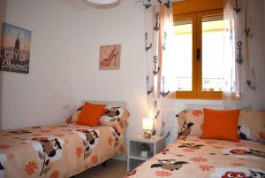 a bedroom with two beds and a window at ROCASOL - Beach in Calpe +11 photos