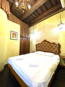 a bedroom with a large bed with white sheets at Квартира подобово на Площі Ринок 39 in Lviv