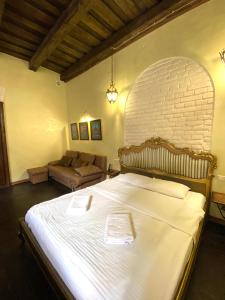 a bedroom with a large bed and a brick wall at Квартира подобово на Площі Ринок 39 in Lviv