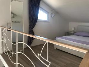 a small bedroom with a bed and a mirror at Apartment Purple Loft in Hvar