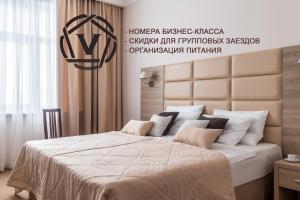 a bedroom with a large bed with a large headboard at Hotel "VITAMIN" in Krasnodar